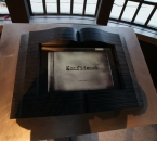 Muzeum Historyczne Miasta Krakowa - Fabryka Schindlera - Sala Wyborów - księga ze szkła czarnego klejonego warstwowo na postumencie ze stali nierdzewnej